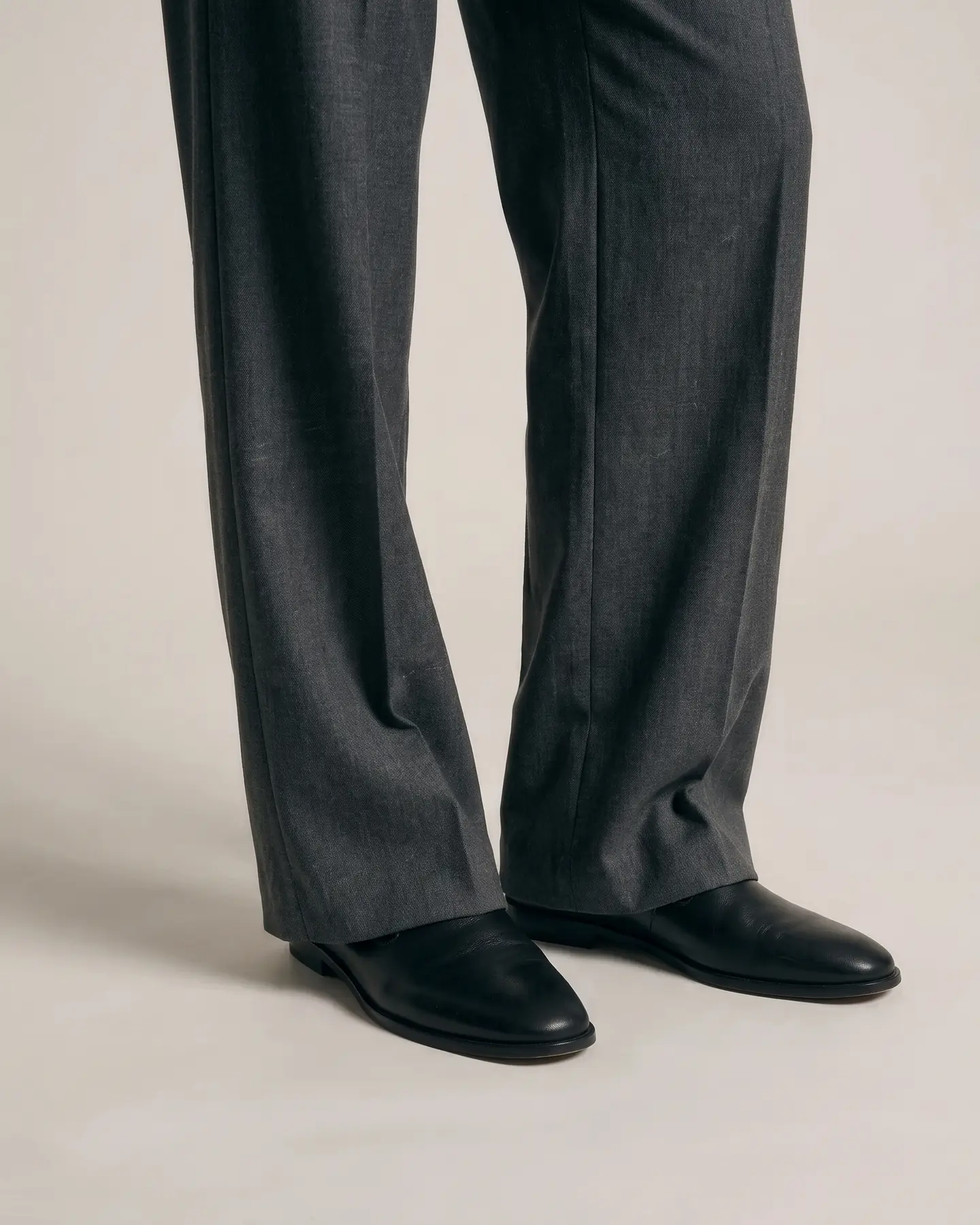 A close pass on the hem where the trouser breaks over the shoe